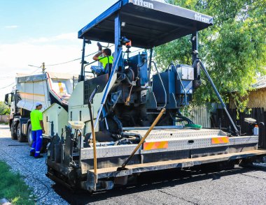 İşçiler ve asfaltlama makineleri. İnşaat, Avrupa Birliği yapısal fonlarının desteğiyle yeni karayolunun asfaltlanması. Targoviste, Romanya, 2020.