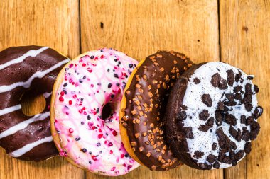 Masada fotokopi alanı olan renkli çörekler. İzole edilmiş donutların üst görünümü.