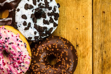 Masada fotokopi alanı olan renkli çörekler. İzole edilmiş donutların üst görünümü.