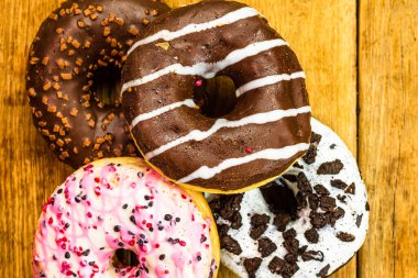 Masada fotokopi alanı olan renkli çörekler. İzole edilmiş donutların üst görünümü.
