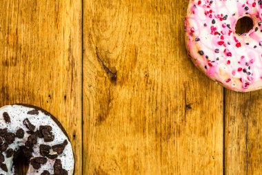 Masada fotokopi alanı olan renkli çörekler. İzole edilmiş donutların üst görünümü.
