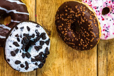Masada fotokopi alanı olan renkli çörekler. İzole edilmiş donutların üst görünümü.