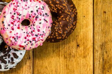 Masada fotokopi alanı olan renkli çörekler. İzole edilmiş donutların üst görünümü.