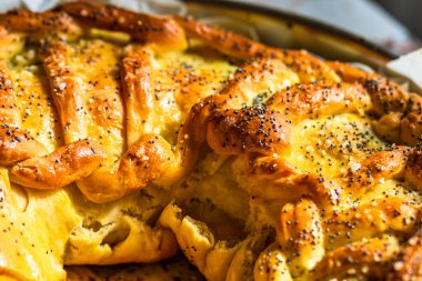 Örülmüş poğaça üzerine tuz ve haşhaş tohumlarının detaylarına odaklanmış seçici bir fotoğrafla kapat..