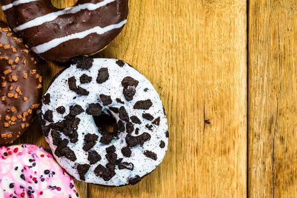 Masada fotokopi alanı olan renkli çörekler. İzole edilmiş donutların üst görünümü.