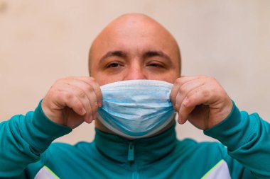 Tıbbi maske portresi olan hasta genç adam arka planda bulanık pandemik koronavirüs hastalığını gösteriyor. Covid-19 salgın kirliliği kavramı