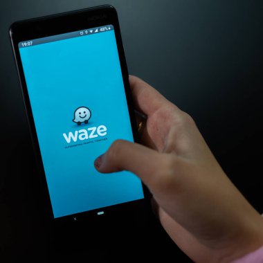 Akıllı telefonda waze uygulaması kullanan kadın elleri. Bükreş, Romanya, 2020.