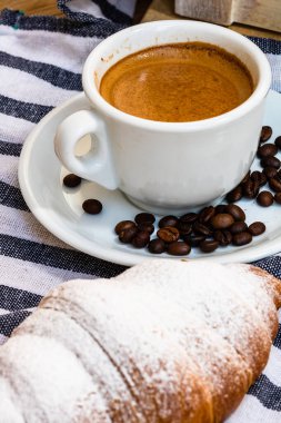 Puf böreği, kahve fincanı ve ahşap sandıkta tereyağlı Fransız kruvasanı. Yemek ve kahvaltı konsepti. Kahve tatlısı ve taze hamur işlerinin detayları.