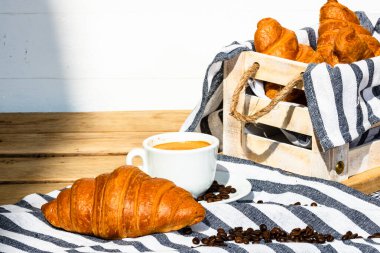 Puf böreği, kahve fincanı ve ahşap sandıkta tereyağlı Fransız kruvasanı. Yemek ve kahvaltı konsepti. Kahve tatlısı ve taze hamur işlerinin detayları.