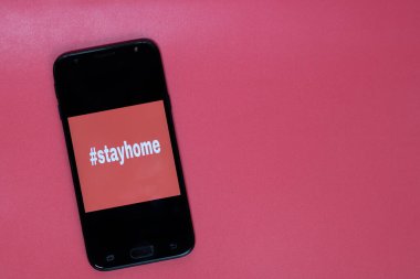 Etiket akıllı telefonun ekranında evde kalıp mesajlaşmak. Tıbbi koruma ekipmanları izole edildi. Grip virüsü yayılıyor, virüs koruma yöntemleri.