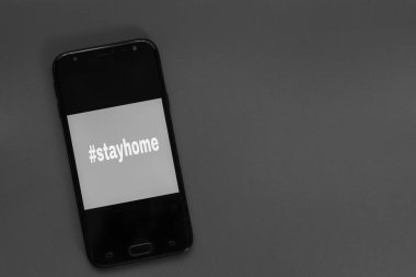 Etiket akıllı telefonun ekranında evde kalıp mesajlaşmak. Tıbbi koruma ekipmanları izole edildi. Grip virüsü yayılıyor, virüs koruma yöntemleri.