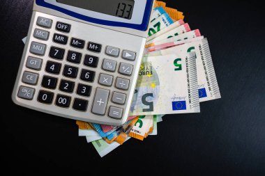 Dünya para kavramı, EURO para birimi ve siyah tablo üzerinde hesap makinesi
