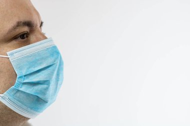 Tıbbi koruyucu yüz maskesi olan beyaz bir genç adam salgın koronavirüsü gösteriyor. Beyazlar üzerinde izole edilmiş Covid 19 hastalığı. Covid-19 salgını, grip salgını ve sağlık konsepti