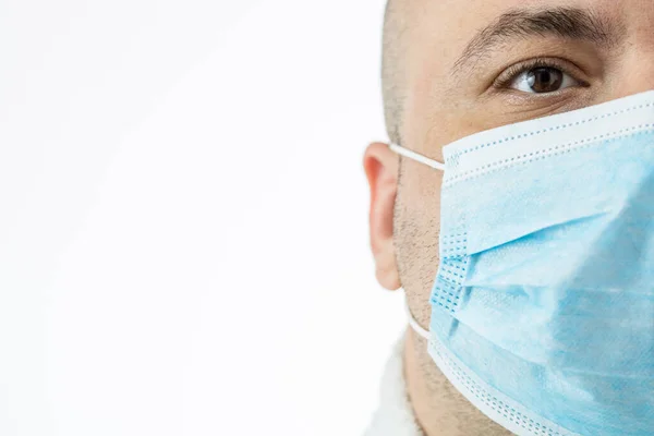 Caucasian young man with medical protective face mask illustrates pandemic coronavirus, Covid 19 disease isolated on white. Covid-19 outbreak, flu contamination and healthcare concept