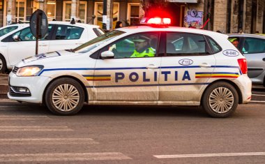Romanya polisi (Politia Rutiera) arabası, Romanya 'nın başkenti Bükreş' te 2020 yılında COVID-19 'un yaygınlaşması üzerine sokağa çıkma yasağı ihlallerini önlemek için ışıklar yanıp sönen sokaklarda devriye geziyor.