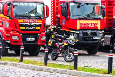 Romanya 'nın Bükreş kentindeki İçişleri Bakanlığı (İçişleri Bakanlığı) önünde park etmiş motorsikletli acil durum itfaiyecileri (Pompierii). Motosiklette SMURD acil servisi