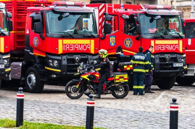 Romanya 'nın Bükreş kentindeki İçişleri Bakanlığı (İçişleri Bakanlığı) önünde park etmiş motorsikletli acil durum itfaiyecileri (Pompierii). Motosiklette SMURD acil servisi