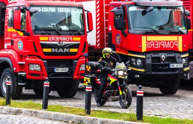 Romanya 'nın Bükreş kentindeki İçişleri Bakanlığı (İçişleri Bakanlığı) önünde park etmiş motorsikletli acil durum itfaiyecileri (Pompierii). Motosiklette SMURD acil servisi