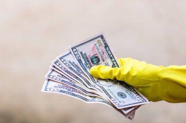 Dünya para kavramı, eldiven alma, 50 dolarlık banknot verme ya da tutma, bulanık arka planda izole edilmiş. Corona virüsü COVID-19 salgını. Virüsün yayılmasını önleme kavramı