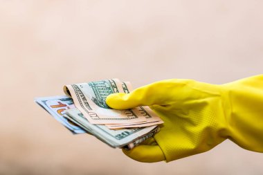 Dünya para kavramı, eldiven alma, USD banknot verme veya tutma, bulanık arka planda izole. Corona virüsü COVID-19 salgını. Virüsün yayılmasını önleme kavramı