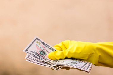 Dünya para kavramı, eldiven alma, 50 dolarlık banknot verme ya da tutma, bulanık arka planda izole edilmiş. Corona virüsü COVID-19 salgını. Virüsün yayılmasını önleme kavramı