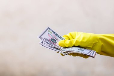 Dünya para kavramı, eldiven alma, 50 dolarlık banknot verme ya da tutma, bulanık arka planda izole edilmiş. Corona virüsü COVID-19 salgını. Virüsün yayılmasını önleme kavramı