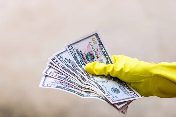 World money concept, hand with gloves receiving, giving or holding 50 USD banknote, isolated on blurred background. Corona virus COVID-19 outbreak. Concept of prevention virus spread