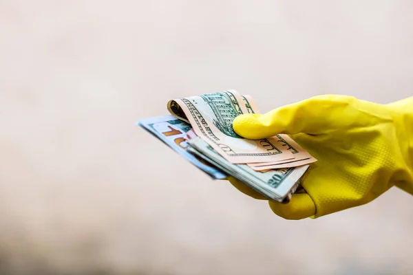 Dünya para kavramı, eldiven alma, USD banknot verme veya tutma, bulanık arka planda izole. Corona virüsü COVID-19 salgını. Virüsün yayılmasını önleme kavramı