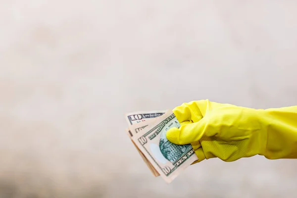 World money concept, hand with gloves receiving, giving or holding 10 USD banknote, isolated on blurred background. Corona virus COVID-19 outbreak. Concept of prevention virus spread