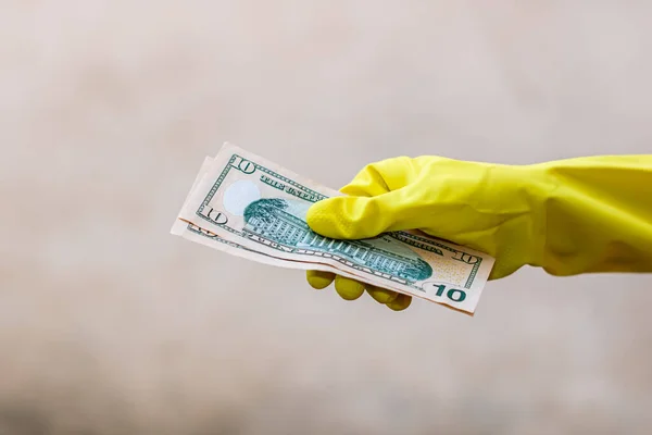 World money concept, hand with gloves receiving, giving or holding 10 USD banknote, isolated on blurred background. Corona virus COVID-19 outbreak. Concept of prevention virus spread