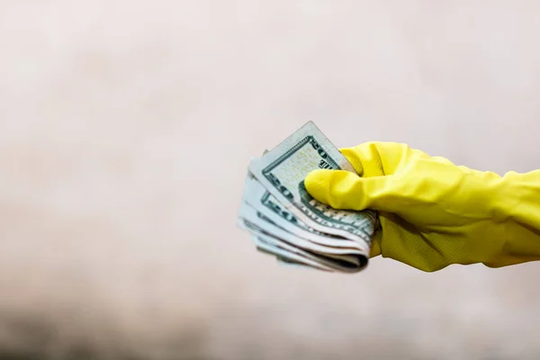 World money concept, hand with gloves receiving, giving or holding 20 USD banknote, isolated on blurred background. Corona virus COVID-19 outbreak. Concept of prevention virus spread