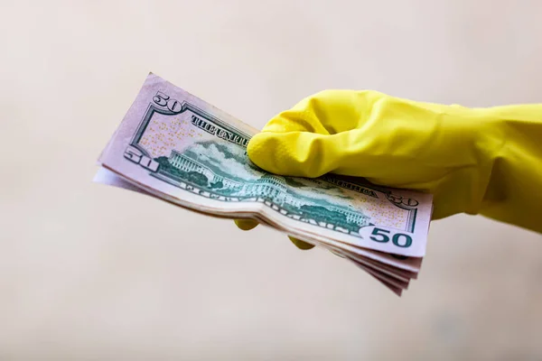 World money concept, hand with gloves receiving, giving or holding 50 USD banknote, isolated on blurred background. Corona virus COVID-19 outbreak. Concept of prevention virus spread