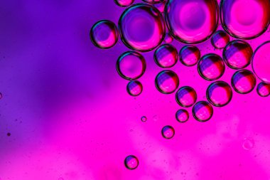 Su yüzeyinde yağ damlaları ve dalgaları olan soyut renkli arkaplan. Soyut arkaplan kavramı