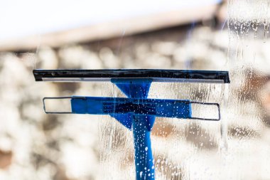 Pencereyi temizleyen adam cam temizleyicisi, temizleyici sprey, temizlik hizmeti konsepti kullanıyor. Ev işleri ve ev idaresi kavramı