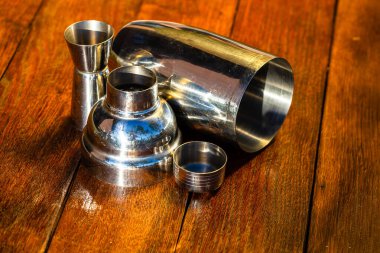 Kokteyl karıştırıcı aksesuarlar ve tahta bir tahtanın üzerinde shot bardakları. Bar aletleri, içki konsepti.