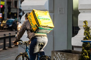 Bisikletli bir Glovo yemek kuryesi. Restoranlar kapalı ve Romanya 'nın Bükreş kentindeki Coronavirus COVID-19 salgını nedeniyle acil durum döneminde sadece teslimatlara izin veriliyor.