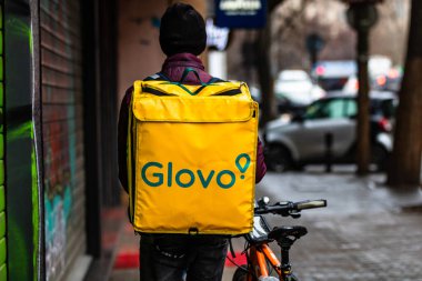Bisikletli bir Glovo yemek kuryesi. Restoranlar kapalı ve Romanya 'nın Bükreş kentindeki Coronavirus COVID-19 salgını nedeniyle acil durum döneminde sadece teslimatlara izin veriliyor.