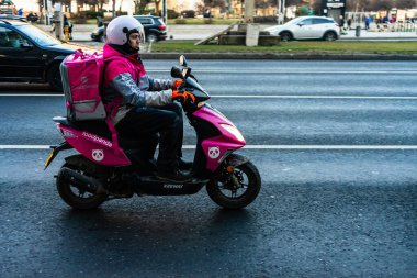 Gıda Pandası yemek dağıtım kuryesi mobiletle geliyor. Restoranlar kapalı ve Romanya 'nın Bükreş kentindeki Coronavirus COVID-19 salgını nedeniyle acil durum döneminde sadece teslimatlara izin veriliyor.