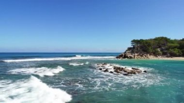 Dalgalar güneşli bir günde Haiti 'deki Labadee Adası' nda kayalara çarpıyor..
