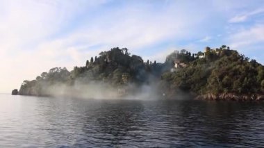 Portofino, İtalya 'da deniz manzarası ve bitki örtüsü. Kıyıya yakın bulutlar.