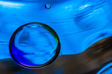 Su yüzeyinde yağ damlaları ve dalgaları olan soyut renkli arkaplan. Soyut arkaplan kavramı