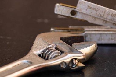 Tamir ve inşaat için aletler. Değiştirilebilir anahtar, cetvel ve enstrümanlar kopyalama alanı olan siyah ahşap masa üzerinde