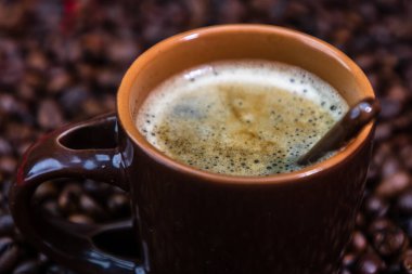 Kırmızı arka planda kavrulmuş kahve çekirdekli kahve fincanı, kahve fotografı.