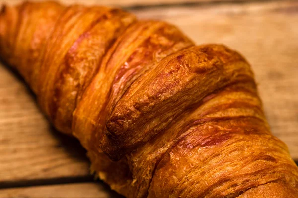 Tahta masadaki taze kruvasanın ayrıntıları. Yemek ve kahvaltı konsepti. Üst görünüm ve kopyalama alanı