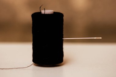 Siyah dikiş ipliği makarasına iğne batır, izole edilmiş, kapat..