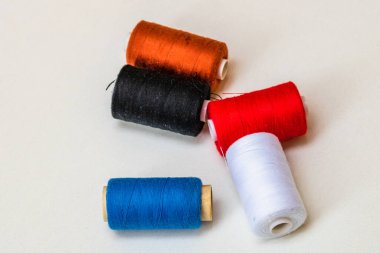 Beyaz arkaplanda izole edilmiş renkli dikiş ipliği makaraları