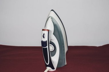 Kopya alanı ile izole edilmiş elektrikli bir demire yakın çekim. Ev çamaşırları ütü yapıyor..