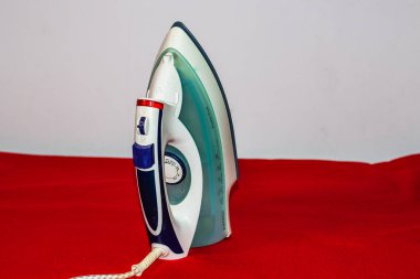 Kopya alanı ile izole edilmiş elektrikli bir demire yakın çekim. Ev çamaşırları ütü yapıyor..