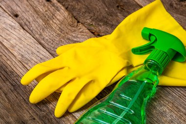 Temizlik spreyi anti bakteriyel dezenfektan spreyi sarı eldivenlerle izole edilmiş, enfeksiyon kontrolü kavramı. Evi veya ofisi temizlemek için fotokopi alanı olan plastik bir şişe.