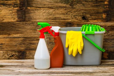 Temizlik spreyi antibakteriyel dezenfektan spreyi. Paspas kovası ve sarı eldivenlerle izole edilmiş. Enfeksiyon kontrolü kavramı. Evini veya ofisini temizlemek için fotokopi alanı olan plastik şişeler